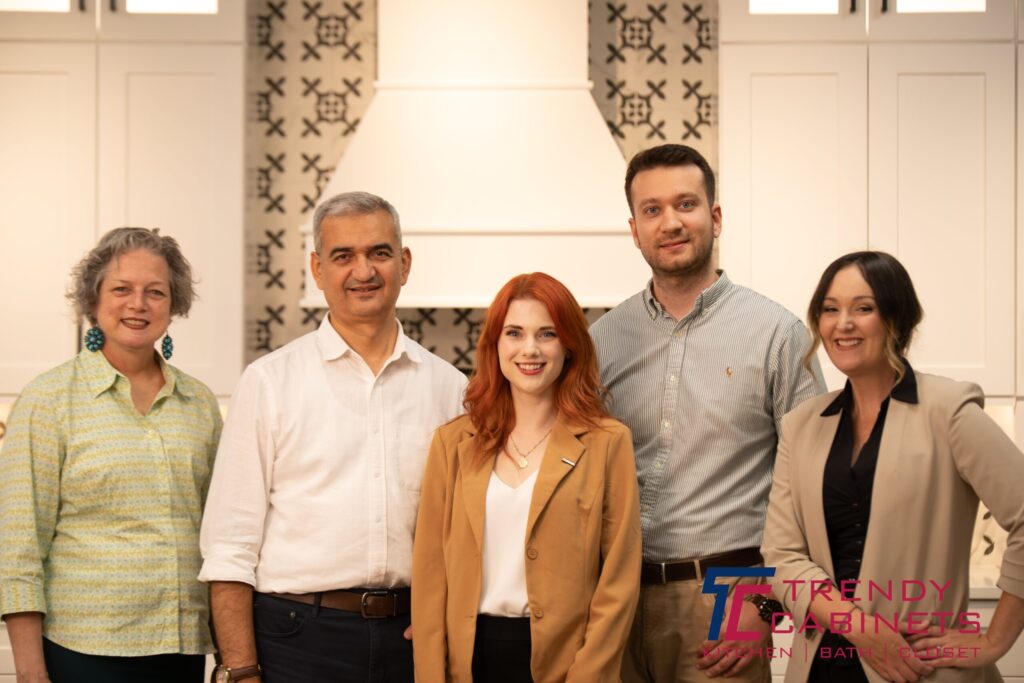 Trendy cabinet family and staff in front of kitchen cabinet showroom